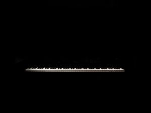 Un teclado de piano sobre fondo negro
